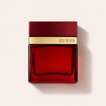 Flakon GUESS Seductive Homme Red EDT 100 ml na pudrově růžovém pozadí – MrRizz
